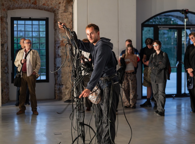 Yein Lee, Luca Büchler: "Poursuivant / Pursuers", performans na odprtju razstave »Komplic« v Cukrarni (MGML, SLO), 21. 5. 2026. Izvajajo Luca Büchler, April Veselko, Anamaria Bagarić.