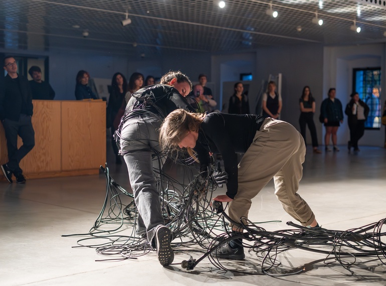 Yein Lee, Luca Büchler: "Poursuivant / Pursuers", performans na odprtju razstave »Komplic« v Cukrarni (MGML, SLO), 21. 5. 2026. Izvajajo Luca Büchler, April Veselko, Anamaria Bagarić.