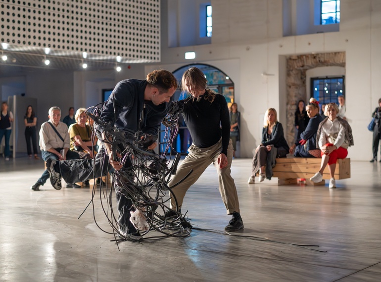 Yein Lee, Luca Büchler: "Poursuivant / Pursuers", performans na odprtju razstave »Komplic« v Cukrarni (MGML, SLO), 21. 5. 2026. Izvajajo Luca Büchler, April Veselko, Anamaria Bagarić.